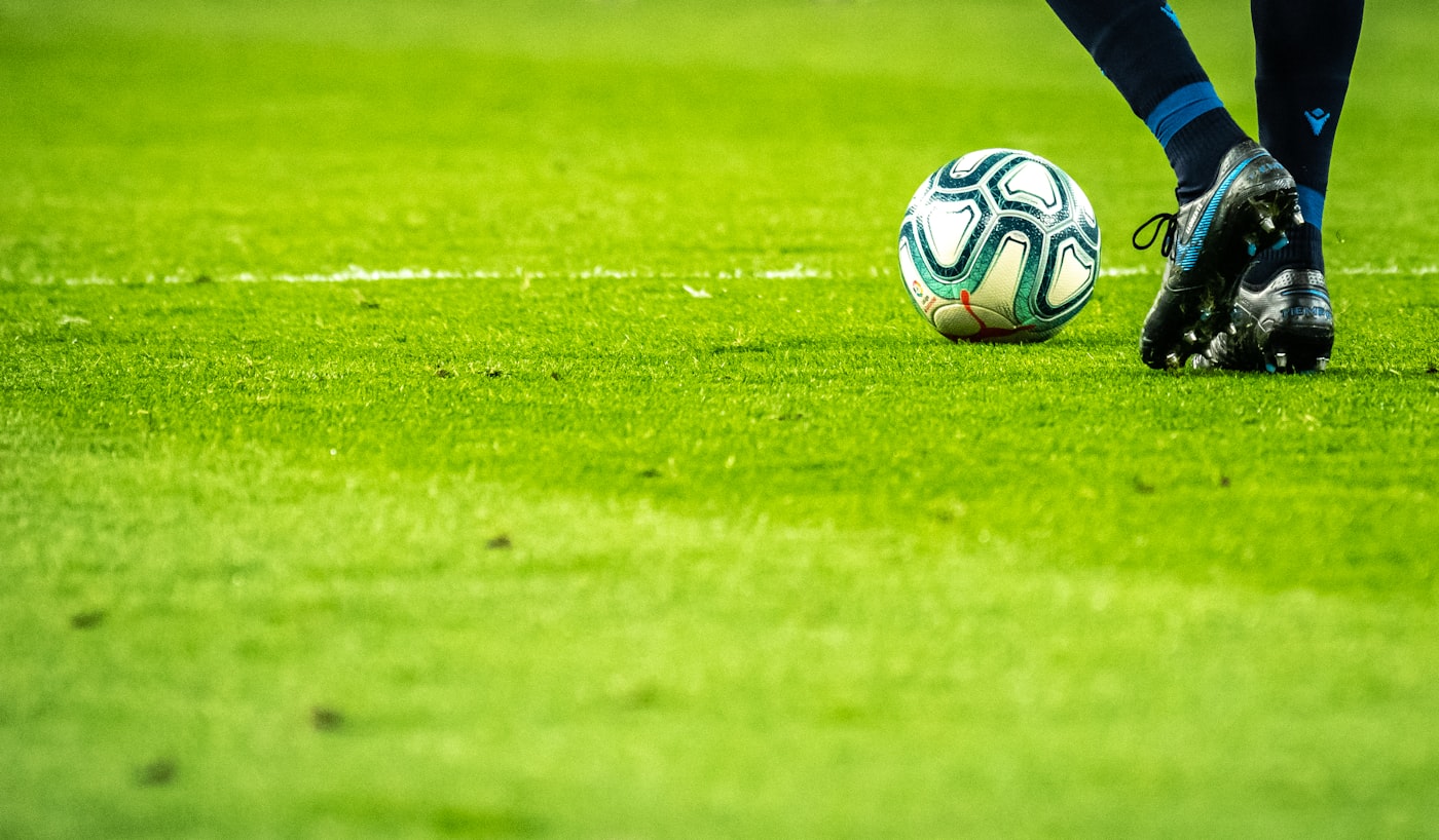 スポーツフィールドでボールを蹴る様子
